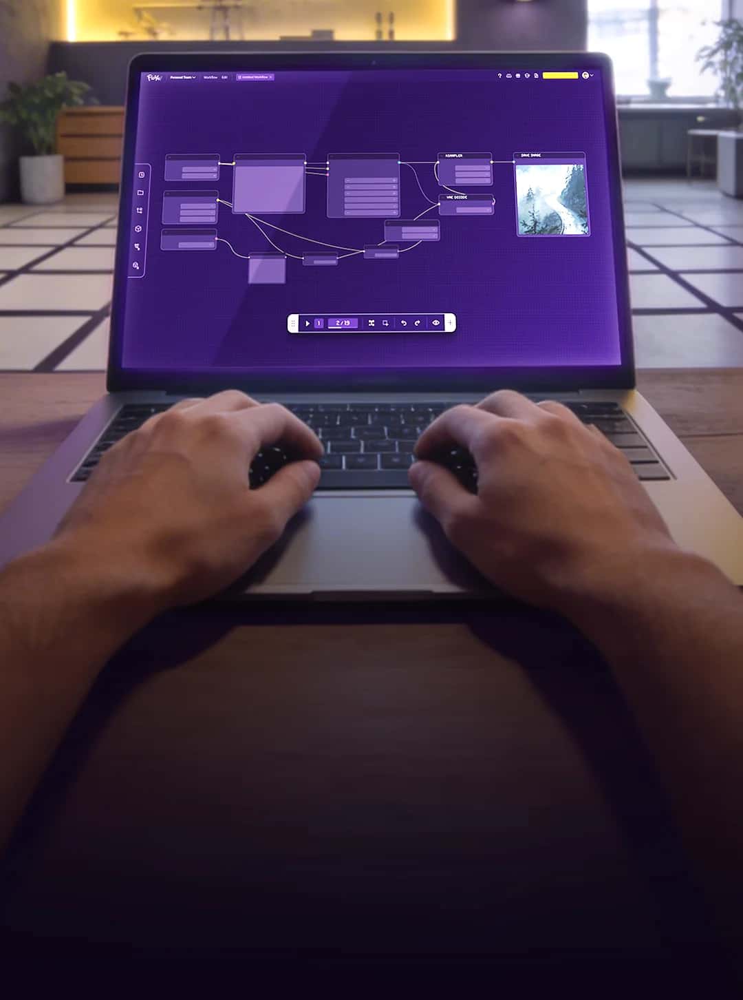 Hands on a laptop showing Floyo workflow editor in a studio environment